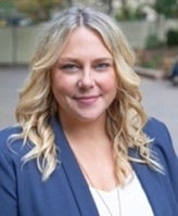A person with blonde hair wearing a blue jacket

Description automatically generated